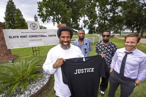 Sullivan Walter, 53, left, holds a shirt near Elayn Hunt Correctional Center in St. Gabriel, La., with, left to right, his brothers Corner Walter, Jr. and Byron Walter, Sr., and Innocence Project New Orleans legal director Richard Davis, just after his release on Thursday, Aug. 25, 2022. (Travis Spradling/The Advocate via AP)