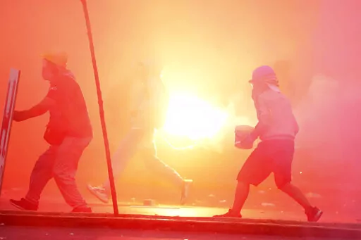 A so-called "deactivator" and "front-line" activist, face off with police during an anti-government protest in Lima, Peru, Saturday, Jan. 28, 2023. Protesters are seeking immediate elections, President Dina Boluarte's resignation, the release of ousted President Pedro Castillo and justice for protesters killed in clashes with police. (AP Photo/Martin Mejia)