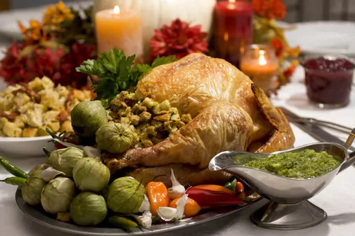 A grill-roasted brined turkey is presented on a table in Concord, N.H. Turkey is the center of most Thanksgiving meals, but it’s important to handle raw poultry properly to avoid spreading bacteria that can send your guests home with an unwanted side of food poisoning.  (AP Photo/Larry Crowe, File)