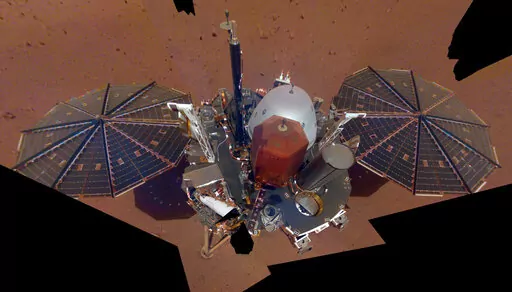 This Dec. 6, 2018 image made available by NASA shows the InSight lander. The scene was assembled from 11 photos taken using its robotic arm. The spacecraft is losing power because of all the dust that's accumulated on its solar panels. NASA said Tuesday, May 17, 2022, it will keep using the spacecraft's seismometer to detect marsquakes until its power peters out. Officials expect operations to cease in July, almost four years after InSight's arrival at Mars. (NASA via AP, File)