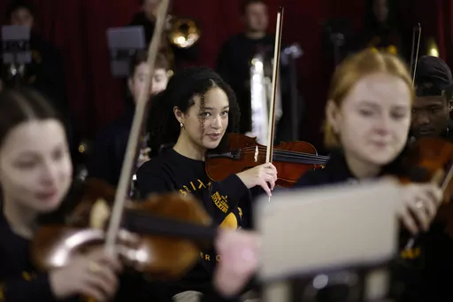 Violinist Adrianna Forbes-Dorant, 17, takes part in a rehearsal with the Brixton Chamber Orchestra for coronation weekend performances in London, Friday, April 21, 2023. Britain's diverse communities will come together to mark King Charles III's coronation. In south London's Brixton, musicians plan to parade through the streets entertaining crowds with a carnival set mix of Gospel, jazz, grime, disco and rap. In west London's Southall, known as “Little India,” British Indians will party with