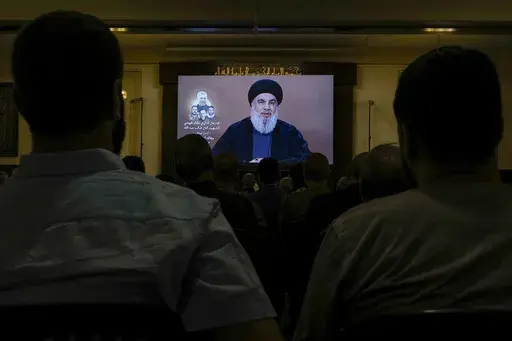 Hezbollah supporters watch a speech given by Hezbollah leader Sayyed Hassan Nasrallah on a screen during a ceremony to commemorate the death of senior Hezbollah commander Taleb Sami Abdullah, 55, who was killed last week by an Israeli strike in south Lebanon, in the southern Beirut suburb of Dahiyeh, Lebanon, Wednesday, June 19, 2024. (AP Photo/Bilal Hussein)