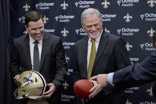 New Orlean Saints new coach Kellen Moore Kellen Moore, left, and Saints general manager Mickey Loomis, right, smile during an NFL football press conference in Metairie, La. Thursday, Feb. 13, 2025. (AP Photo/Matthew Hinton)
