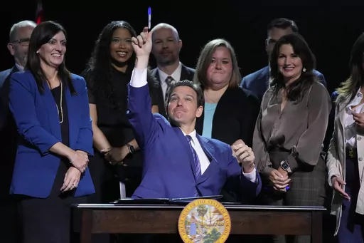 Florida Gov. Ron DeSantis throws a marker into the audience after signing various bills during a bill signing ceremony at the Coastal Community Church at Lighthouse Point, Tuesday, May 16, 2023, in Lighthouse Point, Fla. (AP Photo/Wilfredo Lee)