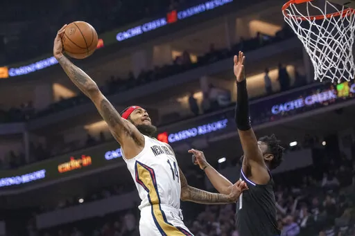 New Orleans Pelicans forward Brandon Ingram (14) dunks against Sacramento Kings forward Chimezie Metu during the first quarter of an NBA basketball game in Sacramento, Calif., Tuesday, April 5, 2022. (AP Photo/Randall Benton)