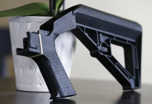 A bump stock is displayed on March 15, 2019, in Harrisonburg, Va. A federal appeals court was told Tuesday, Sept. 13, 2022, that there is no basis in federal law for a Trump administration ban on bump stocks — devices that enable a shooter to fire multiple rounds from semi-automatic weapons with a single trigger pull. (AP Photo/Steve Helber, File)