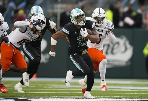 Tulane running back Makhi Hughes (21) carries past UTSA linebackers Martavius French (10) and Avery Morris on a 58-yard run in the first half of an NCAA college football game in New Orleans, Friday, Nov. 24, 2023. (AP Photo/Gerald Herbert, File)