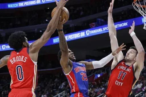Detroit Pistons guard Marcus Sasser (25) goes to the basket against New Orleans Pelicans forward Keion Brooks Jr. (0) and center Karlo Matkovic (17) during the first half of an NBA basketball game Sunday, March 23, 2025, in Detroit. (AP Photo/Duane Burleson)