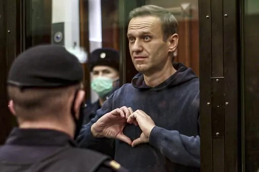 In this handout photo taken from video provided by the Moscow City Court on Feb. 2, 2021, Russian opposition leader Alexei Navalny shows a heart symbol while standing in a defendants' cage during a hearing in the Moscow City Court in Moscow, Russia. President Vladimir Putin says he supported an idea to release Navalny in a prisoner exchange just days before the man who was his biggest foe died. (Moscow City Court via AP, File)