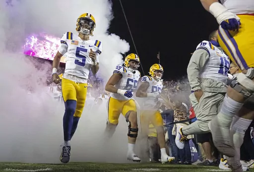 LSU quarterback Jayden Daniels (5) takes the field with offensive lineman Charles Turner III (69) and tight end Mason Taylor (86) before the kickoff of an NCAA college football game against Florida, Saturday, Nov. 11, 2023, in Baton Rouge, La. ( Hilary Scheinuk/The Advocate via AP)