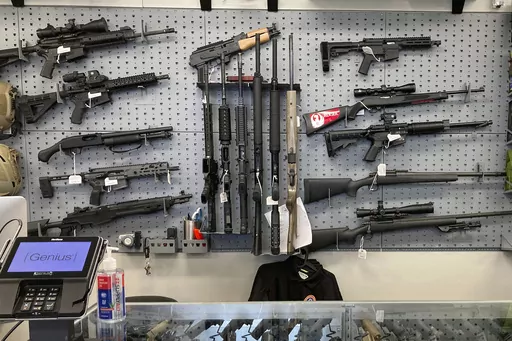 Firearms are displayed at a gun shop in Salem, Ore., Feb. 19, 2021. A federal judge has ruled Oregon's voter-approved gun control measure, one of the toughest in the nation, is constitutional. Oregon voters in November narrowly passed Measure 114, which requires residents to undergo safety training and a background check to obtain a permit to buy a gun. The Oregon measure's fate has been carefully watched as one of the first new gun restrictions passed since the Supreme Court ruling last June. (