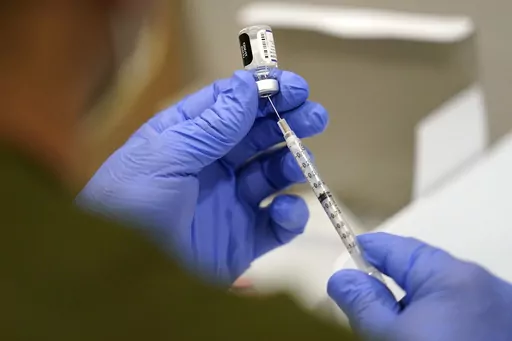 A healthcare worker fills a syringe with the Pfizer COVID-19 vaccine at Jackson Memorial Hospital, Oct. 5, 2021, in Miami. Three years after COVID-19 vaccines became widely available in the United States, Louisiana continues to debate policies related to inoculation mandates, including civil labilities if a work place mandates vaccines or not and a bill that would prohibit schools from requiring students to receive the vaccine. (AP Photo/Lynne Sladky, File)