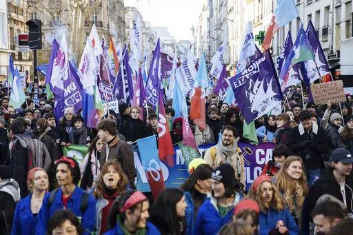 Protestors wave flags during a rally, called by left-wing La France Insoumise (LFI) party and Youth organizations, to protest against the French President's pension reform, in Paris, Saturday, Jan. 21, 2023. (AP Photo/Lewis Joly)