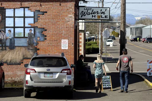 Customers walk toward the Last Waterin' Hole restaurant in North Plains, Ore., on March 17, 2023. In an attempt to attract semiconductor companies to Oregon, the state Legislature on Thursday, April 6, 2023, authorized the governor to expand urban growth boundaries to provide land for chip makers to build factories and provides over $200 million in grants to chipmakers. (AP Photo/Andrew Selsky, File)