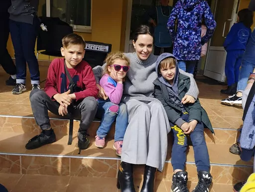 In this image provided by the Lviv city hall Angelina Jolie, Hollywood movie star and UNHCR goodwill ambassador, poses for photo with kids in Lviv, Ukraine, Saturday, Apr. 30, 2022. Ms Jolie was in Ukraine to meet the children affected by the war and visited hospitals and NGOs helping the injured and displaced. (Maksym Kozutsky/Lviv City Hall via AP)