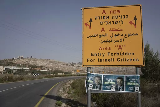 Campaign posters for far-right Israeli lawmaker Bezalel Smotrich, now the Minister of Finance, are strung across a road sign marking an entrance to an area under Palestinian control, near the West Bank town of Nablus, Sunday, Oct. 16, 2022. Smotrich assumed new powers from the military over the occupied territory this year. As the first minister to oversee civilian life in the West Bank, his role amounts to a recognition that Israel's occupation is not temporary, but permanent, observers say. (A