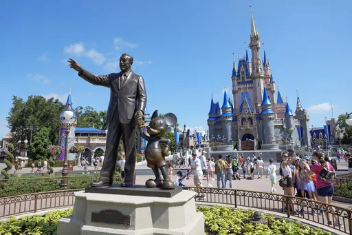 Park guests stroll past the statue of Walt Disney and Mickey Mouse in the Magic Kingdom at Walt Disney World Friday, July 14, 2023, in Lake Buena Vista, Fla. Disney is asking a Florida judge to toss out a lawsuit filed by Gov. Ron DeSantis' appointees to Disney World's governing district. (AP Photo/John Raoux)
