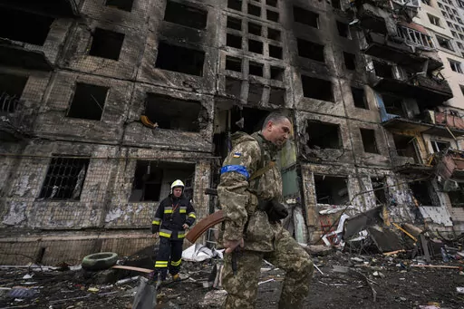 Ukrainian soldiers and firefighters search in a destroyed building after a bombing attack in Kyiv, Ukraine, Monday, March 14, 2022. (AP Photo/Vadim Ghirda, File)