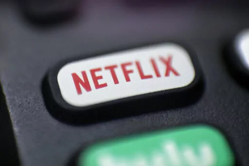 A logo for Netflix is seen on a remote control in Portland, Ore., on Aug. 13, 2020. Netflix will unveil the first version of its video streaming service with ads in November 2022, giving cost-conscious viewers a chance to watch most of its shows at a steep discount in exchange for putting up with commercial interruptions. (AP Photo/Jenny Kane, File)