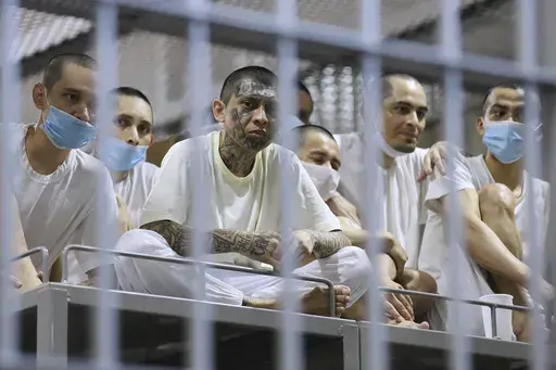Prisoners look out from their cell as the Costa Rica Justice and Peace minister tours the Terrorist Confinement Center in Tecoluca, El Salvador, Friday, April 4, 2025. (AP Photo/Salvador Melendez)