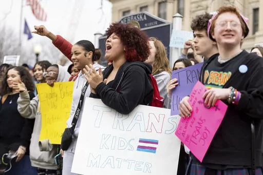 Mae Keller, a senior, carries a "Trans Kids Matter" sign and cheers as hundreds of students walk out of school on Transgender Day of Visibility outside Omaha Central High School on March 31, 2023, in Omaha, Neb. Republican-controlled states across the U.S. are imposing restrictions aimed at transgender students. (Anna Reed/Omaha World-Herald via AP, File)