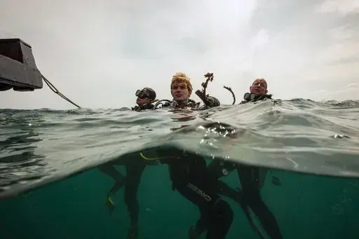 Jonathan Hanitzsch rests after collecting trash off the coast of Hon Mot Island on Feb. 7, 2025, in Nha Trang, Vietnam. (AP Photo/Yannick Peterhans)