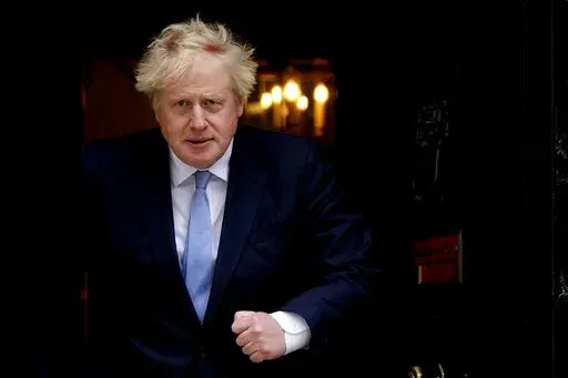 Britain's Prime Minister Boris Johnson walks out the door to meet Norwegian Prime Minister Jonas Gahr Store at 10 Downing Street in London, Friday, May 13, 2022. Johnson is heading to Northern Ireland on Monday, May 16, 2022 to try to end a political deadlock that is preventing the formation of a regional administration. (AP Photo/Frank Augstein, File)