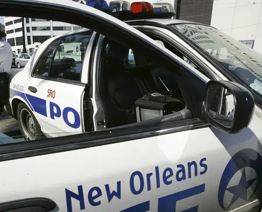 A New Orleans police officer leans against a patrol car, Sept. 11, 2005. (AP Photo/Anja Niedringhaus, file)