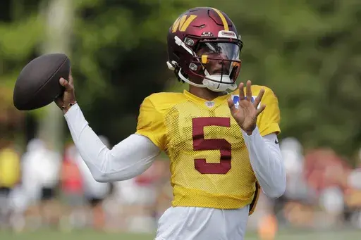 Washington Commanders quarterback Jayden Daniels throws the ball during an NFL football practice at the team's training facility in Ashburn, Va., Sunday, Aug. 4, 2024. (AP Photo/Luis M. Alvarez)