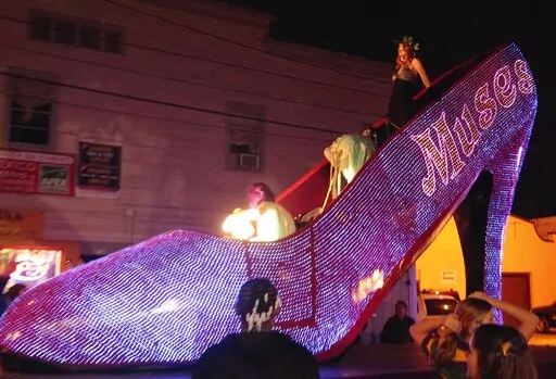Actress Patricia Clarkson holds on as she rides in the Muses Mardi Gras Parade through the streets of New Orleans, Feb. 16, 2012. New Orleans city officials and business owners are celebrating plans to let the good times roll on longer routes with security bolstered by neighboring police agencies. Mayor LaToya Cantrell's official announcement Monday, Jan. 30, 2023, that parade routes were being lengthened was welcome news to Staci Rosenberg, a founder of the Krewe of Muses. (AP Photo/Bill Haber,