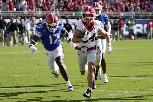 Georgia wide receiver Ladd McConkey (84) runs past Florida linebacker Scooby Williams (17) to score a touchdown on a 41-yard pass play during the first half of an NCAA college football game, Saturday, Oct. 28, 2023, in Jacksonville, Fla. (AP Photo/John Raoux)