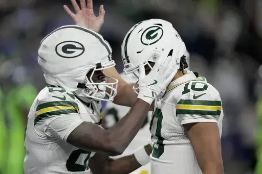 Green Bay Packers' Romeo Doubs celebrates his touchdown catch with Jordan Love during the second half of an NFL football game against the Seattle Seahawks Sunday, Dec. 15, 2024, in Seattle. (AP Photo/Stephen Brashear)