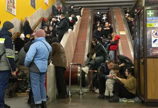 People gather in a subway station being used as a bomb shelter during a Russian rocket attack in Kyiv, Ukraine, Friday, Feb. 10, 2023. (AP Photo/Efrem Lukatsky)