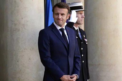 French President Emmanuel Macron greets journalists as he arrives to welcome German Chancellor Olaf Scholz, unseen, at the Elysee Palace in Paris, Wednesday, Oct. 26, 2022. French President Emmanuel Macron is scheduled to meet in Paris with German Chancellor Olaf Scholz amid divergences between the two neighbors and key European Union allies over EU strategy, defense and economic policies. (AP Photo/Christophe Ena)