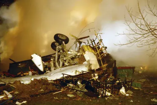 In this Feb. 12, 2009, file photo, the wreckage of Continental flight 3407 lies amid smoke at the scene after crashing into a suburban Buffalo home and erupting into flames. (AP Photo/Dave Sherman, File)