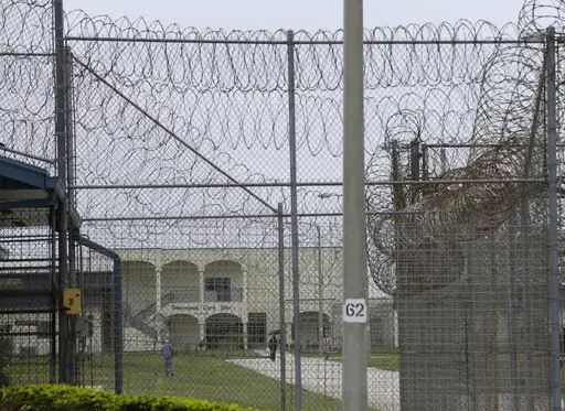A prisoner works on the lawn at the Dade Correctional Institution, July 10, 2014, in Florida City, Fla. (AP Photo/Lynne Sladky, File)