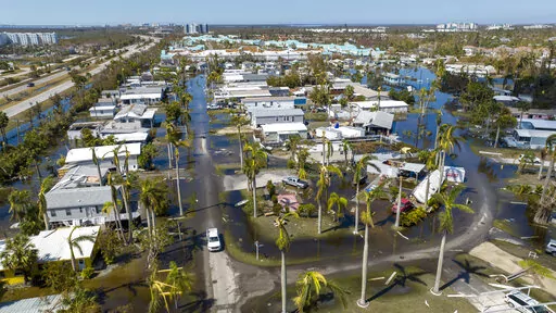 Water floods a damaged trailer park in Fort Myers, Fla., on Oct. 1, 2022, after Hurricane Ian passed by the area. Florida Gov. Ron DeSantis on Thursday, Oct. 13, 2022 announced an executive order expanding voting access for the midterm elections in three counties where Hurricane Ian destroyed polling places and displaced thousands of people. (AP Photo/Steve Helber, File)