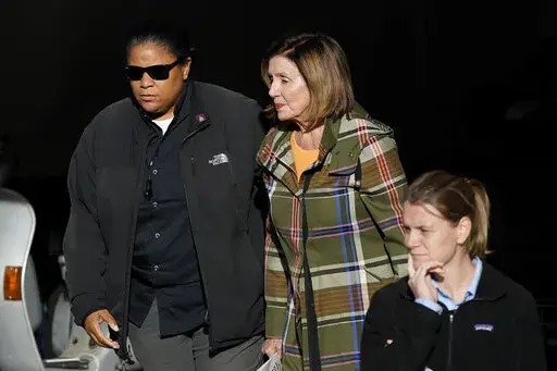 House Speaker Nancy Pelosi, middle, is escorted to a vehicle outside of her and husband Paul Pelosi's home in San Francisco, Wednesday, Nov. 2, 2022. (AP Photo/Jeff Chiu)