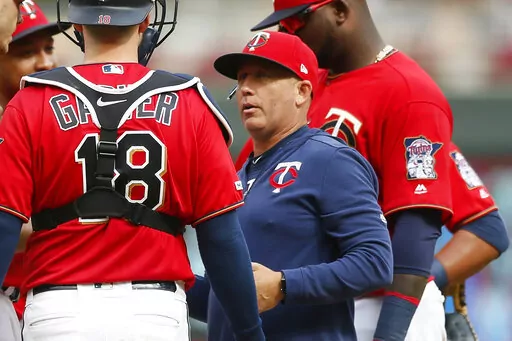 Minnesota Twins pitching coach Wes Johnson, right, holds a meeting on the mound with pitcher Taylor Rogers and catcher Mitch Garver during a baseball game in Minneapolis on Aug. 11, 2019. Johnson has informed the club he will leave his job, reportedly for the same role at LSU. (AP Photo/Jim Mone)