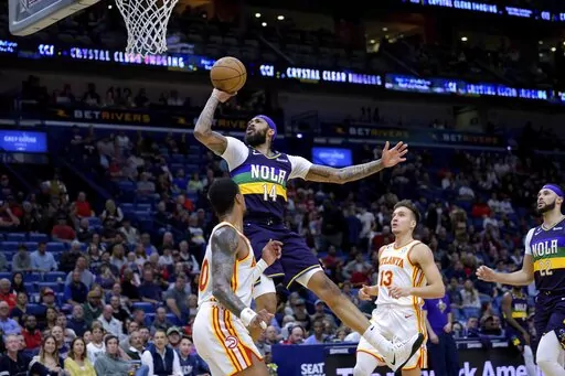 New Orleans Pelicans forward Brandon Ingram (14) shoots over Atlanta Hawks forward John Collins (20) in the first half of an NBA basketball game in New Orleans, Tuesday, Feb. 7, 2023. (AP Photo/Matthew Hinton)