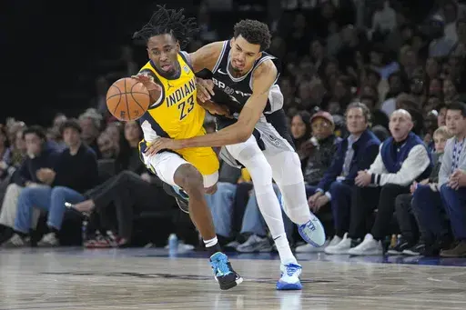 San Antonio Spurs center Victor Wembanyama (1) and Indiana Pacers forward Aaron Nesmith (23) get tangled up as they go for a loose ball during the second half of a Paris Games 2025 NBA basketball game in Paris, Saturday, Jan. 25, 2025. (AP Photo/Thibault Camus)