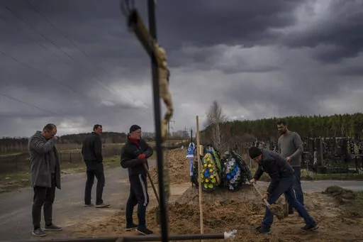 Anatoliy Morykin, 45, left, mourns the death of his mother Valentyna Morykina, 82, who died in a retirement home due to poor living conditions during the Russian invasion in Bucha, on the outskirts of Kyiv, Ukraine, Tuesday, April 12, 2022. (AP Photo/Rodrigo Abd)