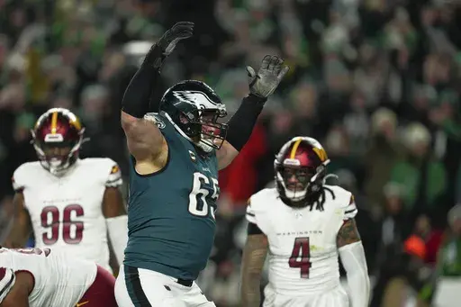 Philadelphia Eagles offensive tackle Lane Johnson (65) celebrates a touchdown by quarterback Jalen Hurts during the second half of the NFC Championship NFL football game against the Washington Commanders, Sunday, Jan. 26, 2025, in Philadelphia. (AP Photo/Derik Hamilton)