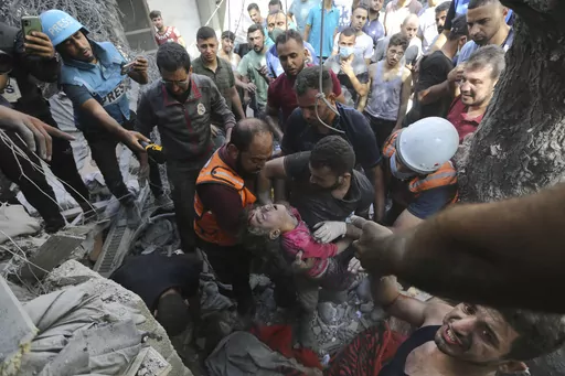Palestinians rescue a child from under the rubble after Israeli airstrikes in Gaza City, Gaza Strip, Wednesday, Oct. 18, 2023. Israel's war on Hamas in the Gaza Strip has the Mideast simmering, raising the temperature on tensions across the region and increasing the risk that seemingly localized conflicts could spin out of control. (AP Photo/Abed Khaled, File)