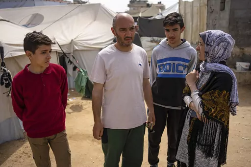 Heba al-Haddad, right, and her family displaced from Gaza City, stand in a makeshift tent camp in Rafah, southern Gaza, Friday, March 29, 2024. Al-Haddad was forced out of her home in Gaza City on March 21 when Israeli troops stormed her apartment and ordered her and her family to leave for the south. Amid fighting that has engulfed the area since Israel raided Shifa Hospital, witnesses say troops have been pushing residents out of nearby neighbourhoods. (AP Photo/Fatima Shbair)
