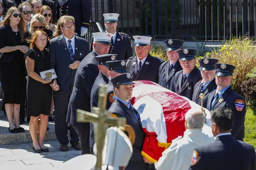 Patrick and Dee Dee Klein, parents of late New York City Firefighter (FDNY) Timothy Klein, follow his casket as it is carried out of St. Francis DeSales Church during a funeral service, Friday, April 29, 2022, in New York. Klein, 31, died Sunday when flames engulfed the second floor of the home, causing part of the ceiling to collapse. (AP Photo/Eduardo Munoz Alvarez)