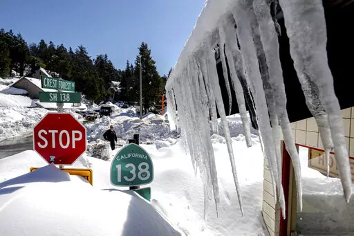 Snowfall surrounds businesses in Crestline, Calif., Friday, March 3, 2023, following a huge snowfall that buried homes and businesses. (Watchara Phomicinda/The Orange County Register via AP)