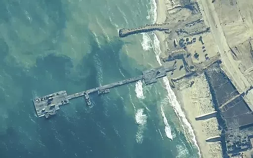 The image provided by U.S, Central Command, shows U.S. Army soldiers assigned to the 7th Transportation Brigade (Expeditionary), U.S. Navy sailors assigned to Amphibious Construction Battalion 1, and Israel Defense Forces placing the Trident Pier on the coast of Gaza Strip on May 16, 2024. A U.S. built temporary pier that had been used to deliver additional humanitarian aid into Gaza was damaged by rough seas and has temporarily suspended operations. That’s according to three U.S. officials wh
