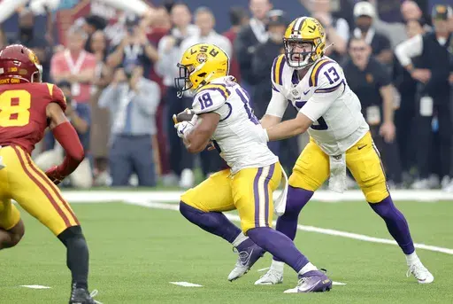 LSU quarterback Garrett Nussmeier (13) hands off to running back Josh Williams (18) during the first half of an NCAA college football game against Southern California, Sunday, Sept. 1, 2024, in Las Vegas. (AP Photo/Steve Marcus)