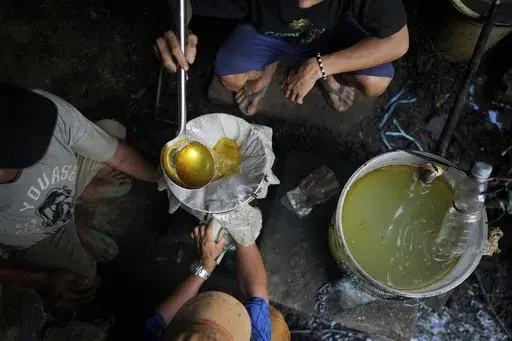 Workers filter patchouli oil at a refinery in Simboro, West Sulawesi, Indonesia, Wednesday, Feb. 26, 2025. (AP Photo/Dita Alangkara)